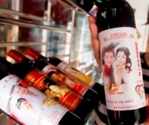 (090211) -- JI'NAN, Feb. 11, 2009 (Xinhua) -- A saleswoman shows a bottle of wine labeled with a photo of a couple in Ji'nan, capital of east China's Shandong Province, Feb. 11, 2009. Various Valentine's Day gifts are sold well across the country with the approach of the St. Valentine's Day, which falls on Feb. 14. (Xinhua/Cui Jian) (kh)